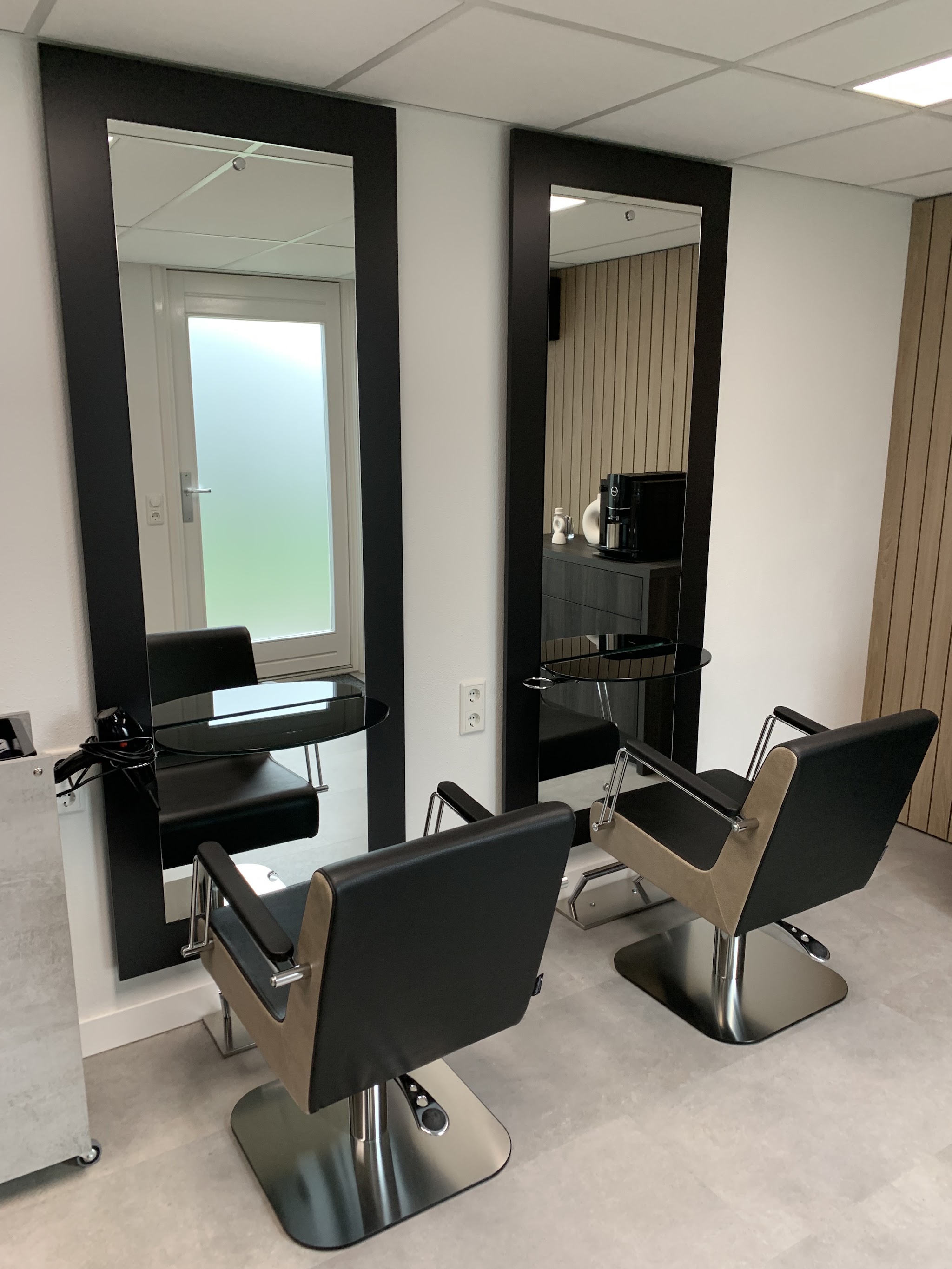 De salon van Sill’s: twee zwarte kappersstoelen voor twee hoge spiegels met zwarte lijst